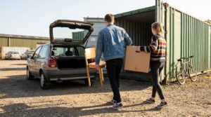 Students loading belongings into a container for the summer